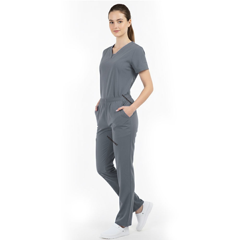 Model placing hand in pocket of Gray scrub pants, showing functionality