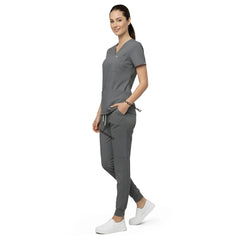 Model demonstrating deep cargo pocket storage on Gray 8-pocket scrub joggers