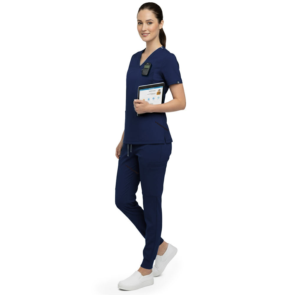 Side profile of nurse holding medical tools wearing Navy Blue rayon scrubs showing athletic fit