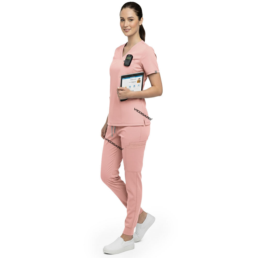 Side profile of nurse holding medical tools wearing Pink rayon scrubs showing athletic fit
