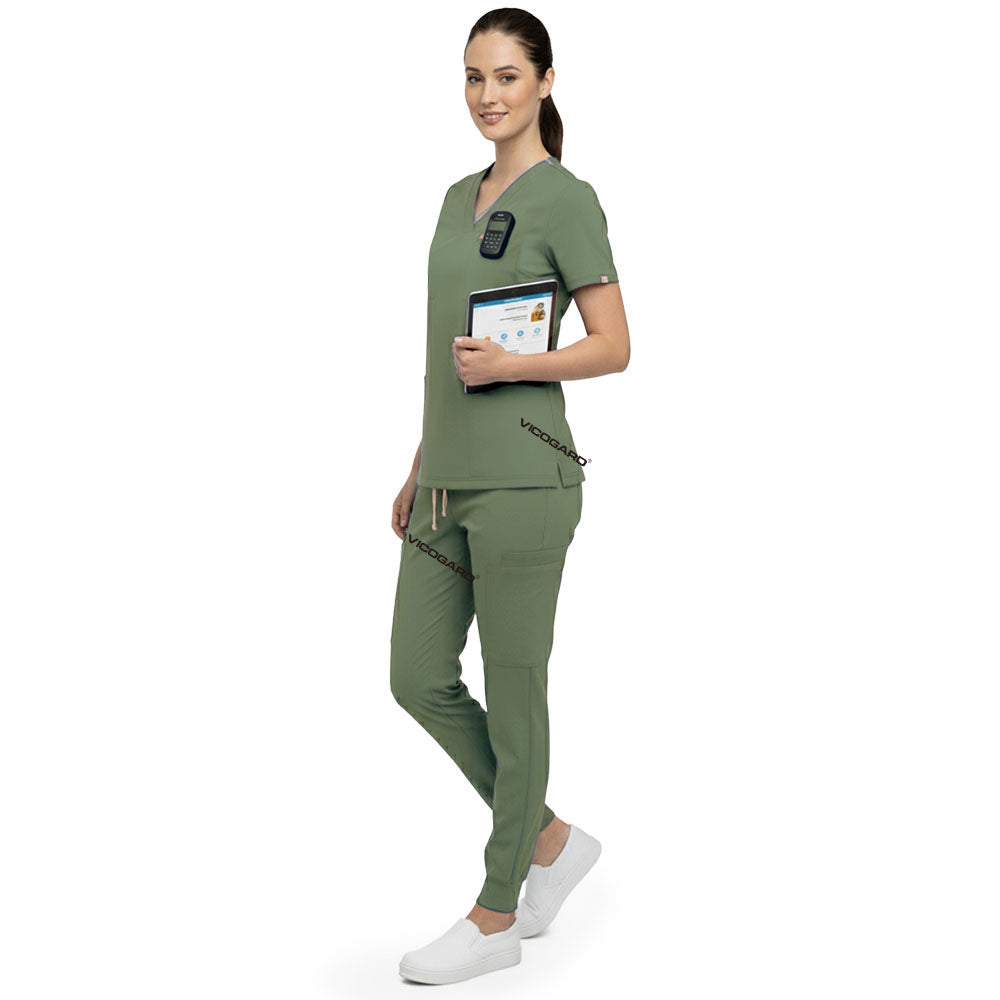 Side profile of nurse holding medical tools wearing Fruit Green rayon scrubs showing athletic fit