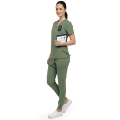 Side profile of nurse holding medical tools wearing Fruit Green rayon scrubs showing athletic fit