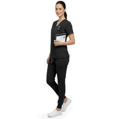 Side profile of beauty professional holding tools wearing Black rayon scrubs showing athletic fit