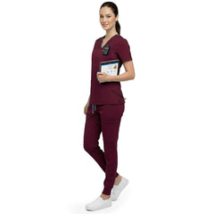 Side profile of nursing student holding clipboard wearing Burgundy rayon scrubs showing athletic fit