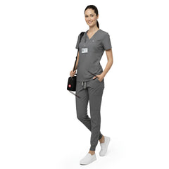 Side profile of dental professional holding tools wearing Gray rayon scrubs showing athletic fit