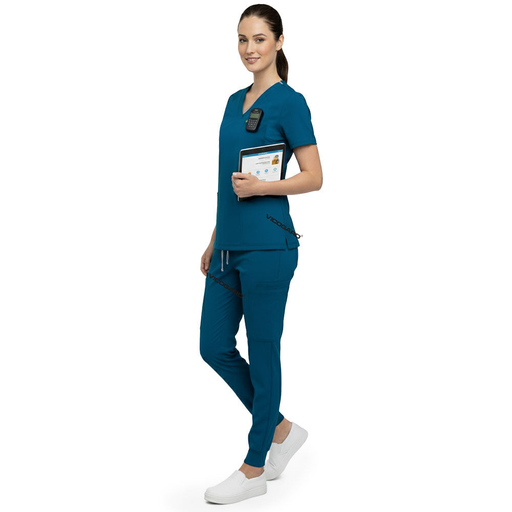 Side profile of nurse holding medical tools wearing Caribbean Blue rayon scrubs showing athletic fit
