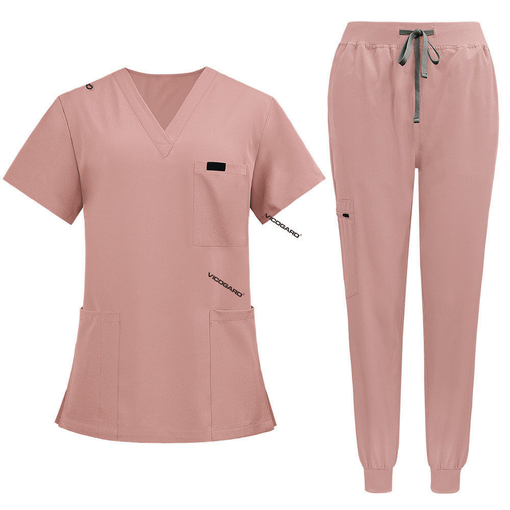 Flat lay of Pink medical uniform featuring curved hem top and zipper pocket jogger pants