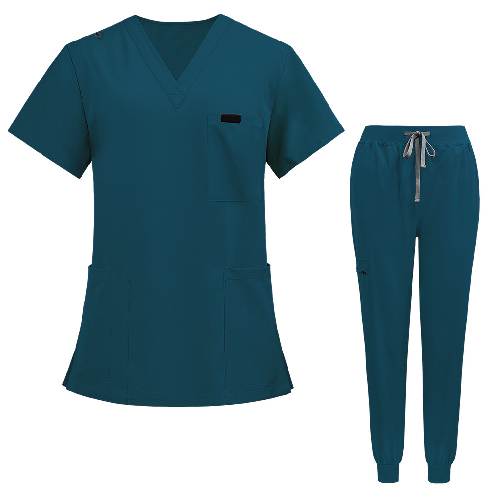 Flat lay of Caribbean Blue medical uniform featuring curved hem top and zipper pocket jogger pants