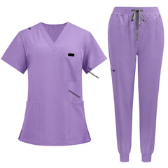 Flat lay of Lavender medical uniform featuring curved hem top and zipper pocket jogger pants