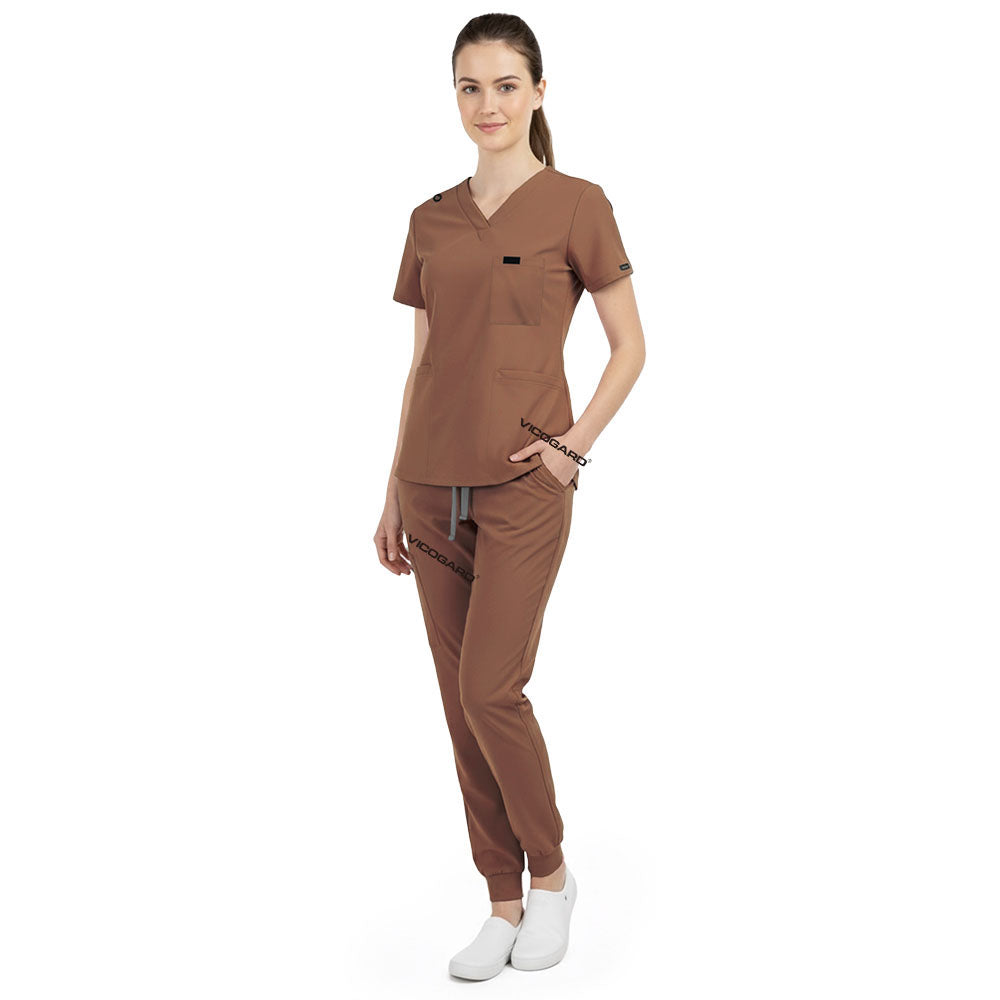 Side view of model using pockets on Coffee scrub pants, showing storage depth