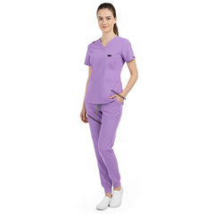 Side view of model using pockets on Lavender scrub pants, showing storage depth