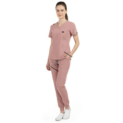 Side view of model using pockets on Pink scrub pants, showing storage depth