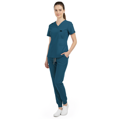 Side view of model using pockets on Caribbean Blue scrub pants, showing storage depth