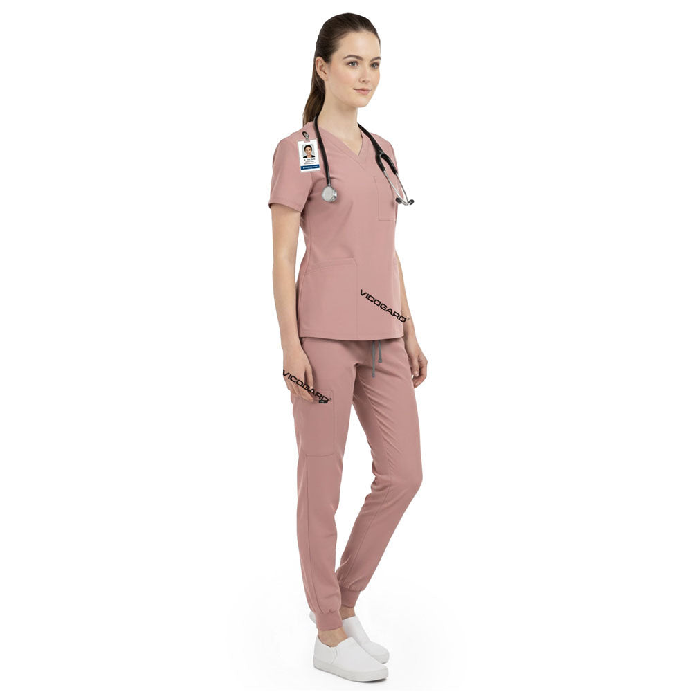 Side view of pediatric nurse working in Pink scrubs, showing professional caring look