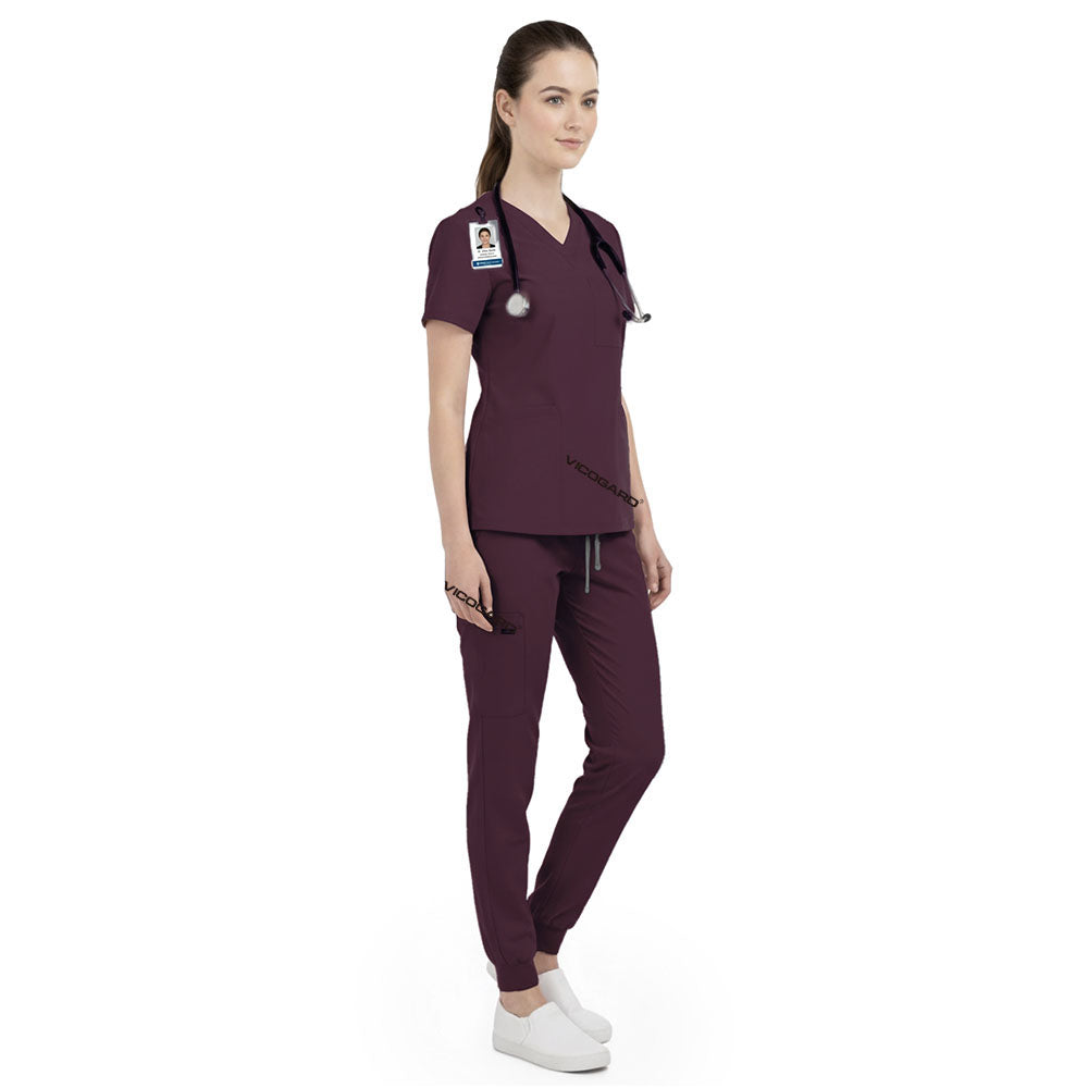 Side view of senior nurse working in Burgundy scrubs, showing authoritative professional look