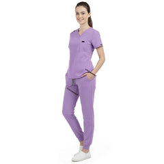 Front view of model with both hands in pockets, demonstrating relaxed fit of Lavender scrubs
