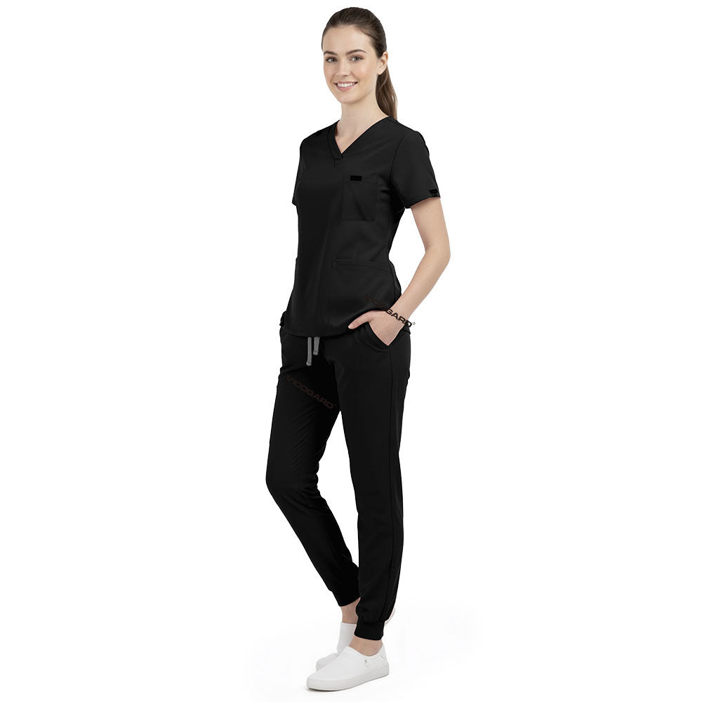 Front view of model with both hands in pockets, demonstrating relaxed fit of Black scrubs