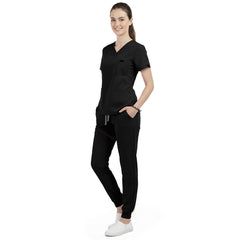 Front view of model with both hands in pockets, demonstrating relaxed fit of Black scrubs