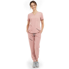 Front view of model with hands in pockets wearing Pink scrubs, showing relaxed athletic fit