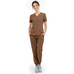 Front view of model with hands in pockets wearing Coffee scrubs, showing relaxed athletic fit