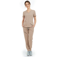 Front view of model with hands in pockets wearing Apricot scrubs, showing relaxed athletic fit