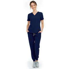 Front view of model with hands in pockets wearing Galaxy Blue scrubs, showing relaxed athletic fit