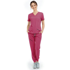 Front view of model with hands in pockets wearing Rose Pink scrubs, showing relaxed athletic fit
