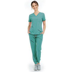 Front view of model with hands in pockets wearing Turquoise scrubs, showing relaxed athletic fit