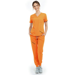 Front view of model with hands in pockets wearing Mango Yellow scrubs, showing relaxed athletic fit