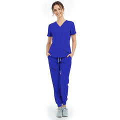 Front view of model with hands in pockets wearing Royal Blue scrubs, showing relaxed fit