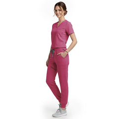 Side view of model using streamlined cargo pocket on Rose Pink scrub pants, showing non-bulky storage