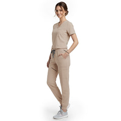 Side view of model using streamlined cargo pocket on Apricot scrub pants, showing non-bulky storage
