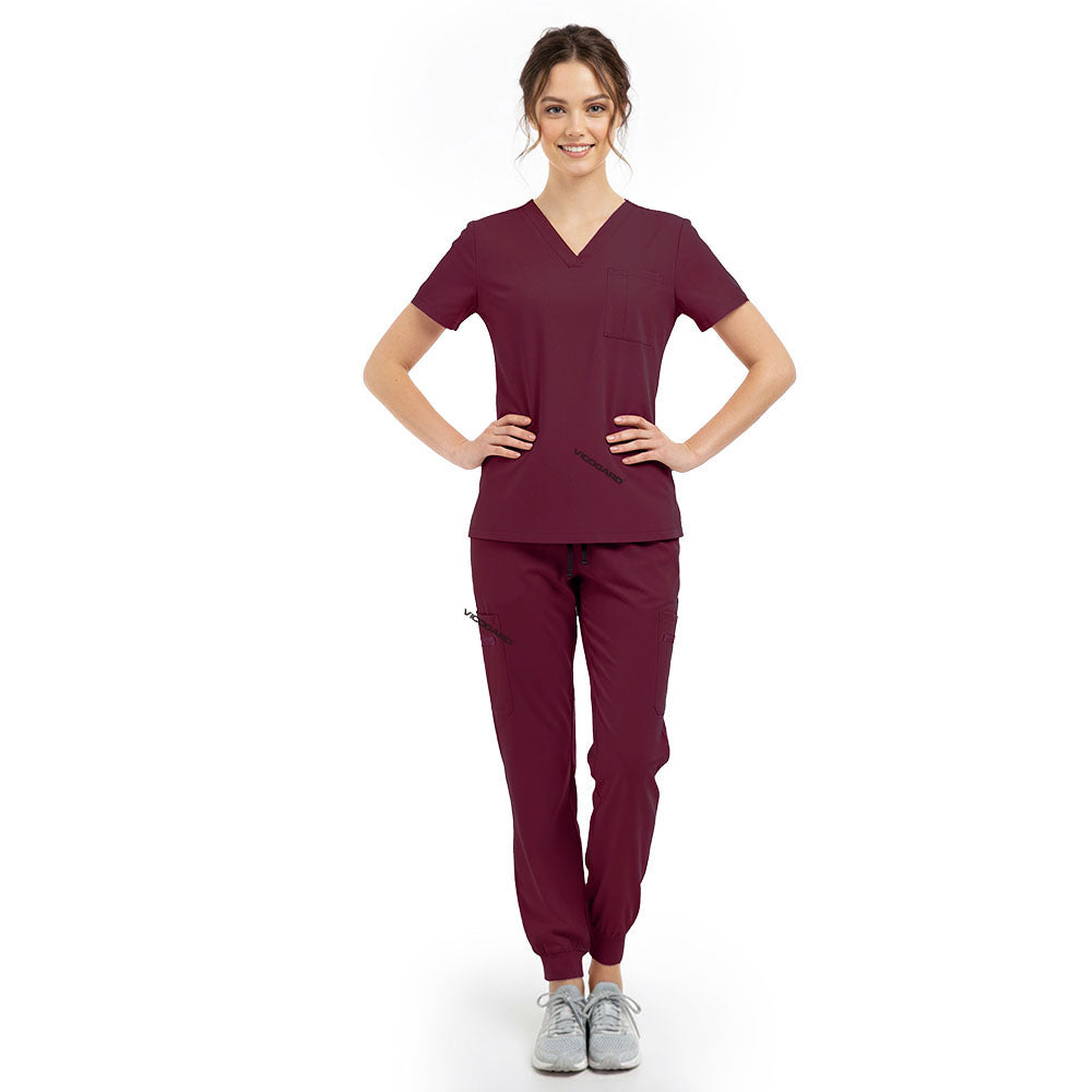 Model pose highlighting the tailored waist silhouette of the Burgundy performance scrub top