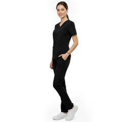 Side view of model using deep cargo pocket on Black scrub pants, showing spacious storage for beauty tools
