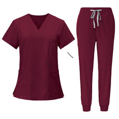 Flat lay of Burgundy scrub set featuring V-neck top and jogger pants