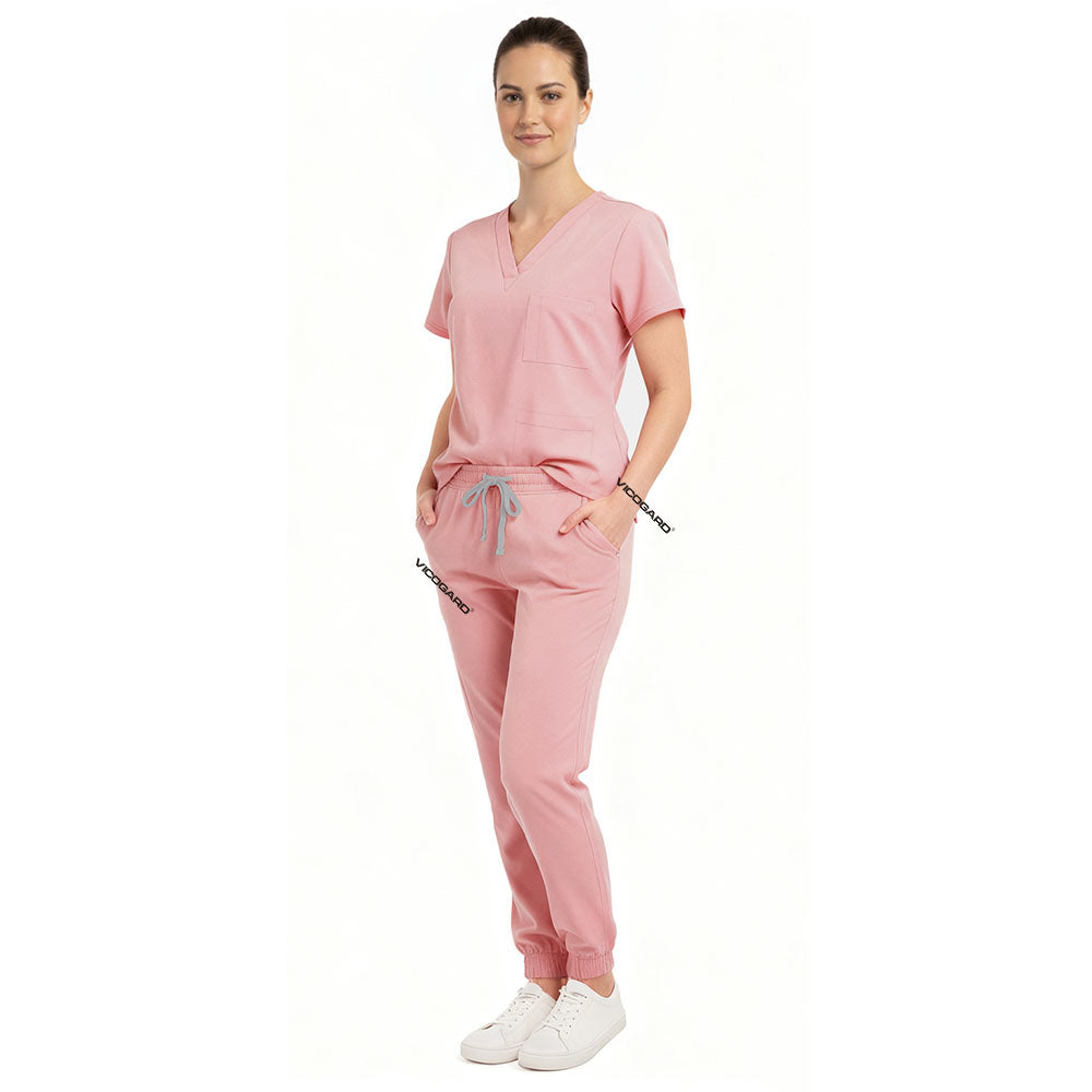 Nurse utilizing functional pockets on Vicogard Pink stretch scrub pants