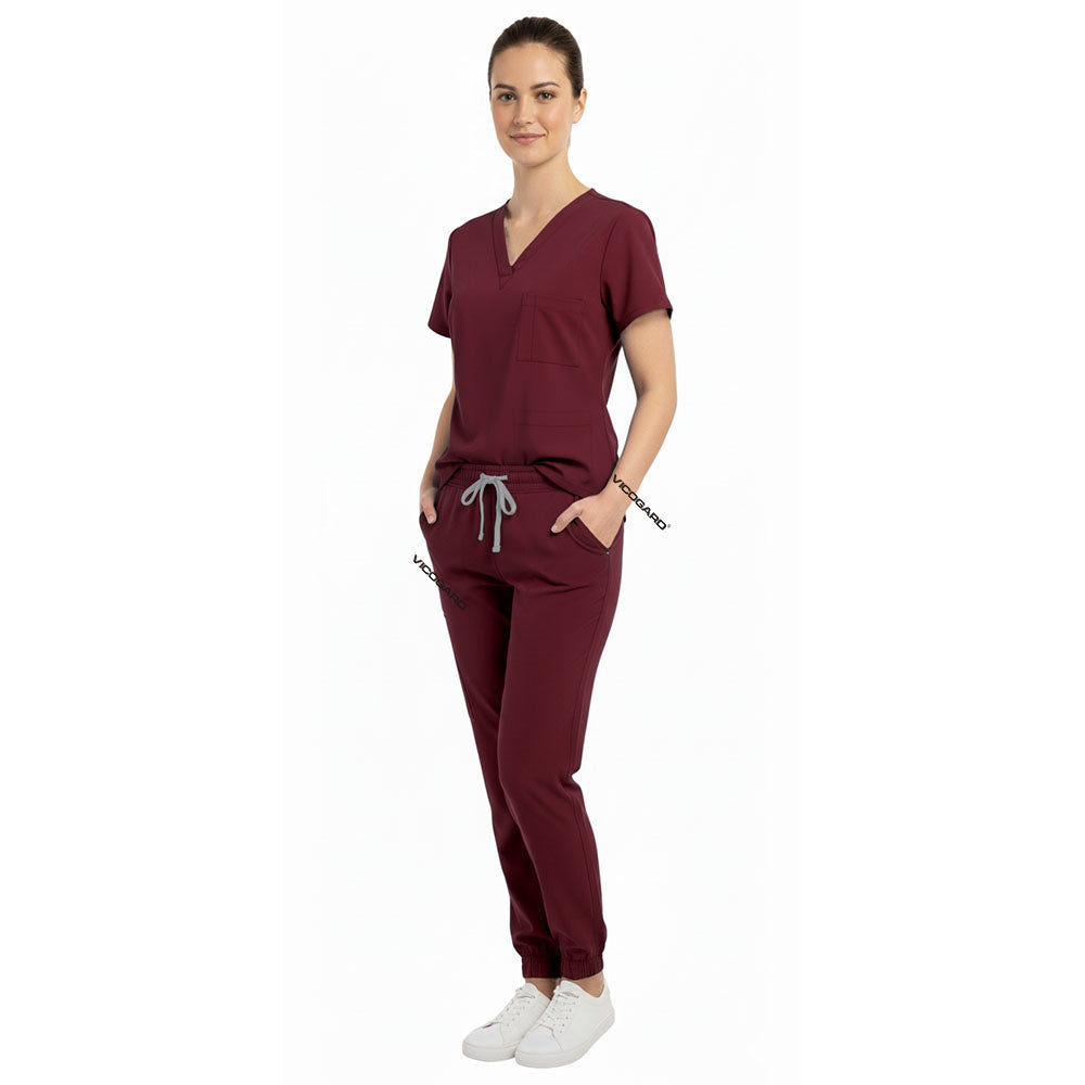 Nurse utilizing functional pockets on Vicogard Burgundy stretch scrub pants